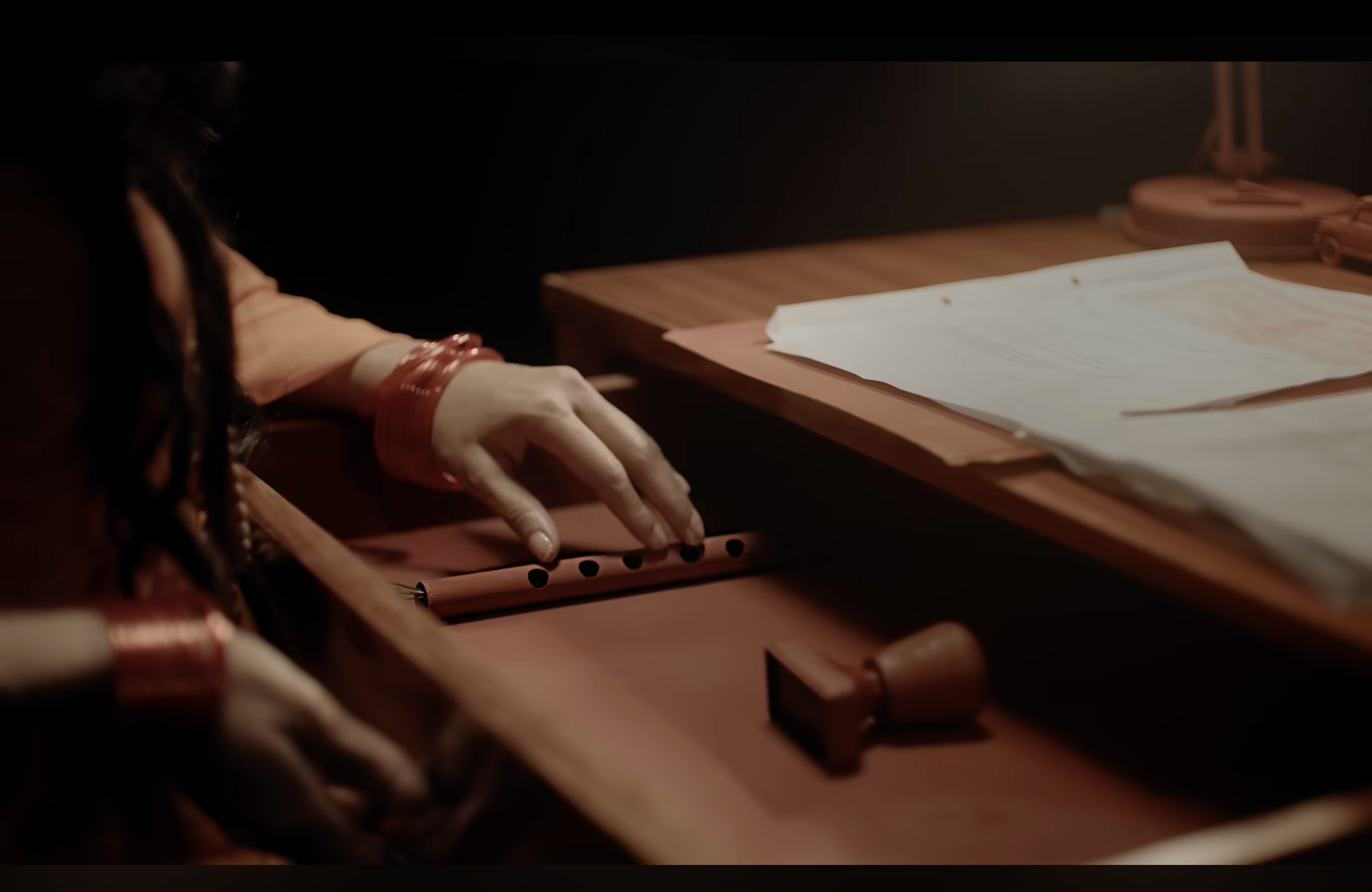 Kaahe Jaage Mohan: Hands beside papers on a desk