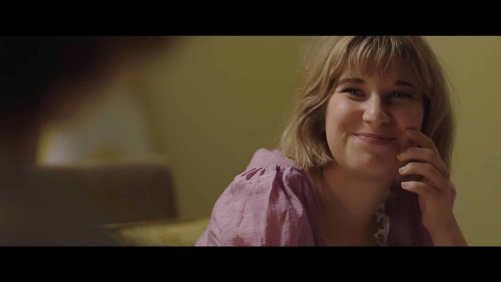 Between Worlds: A woman smiling across a table