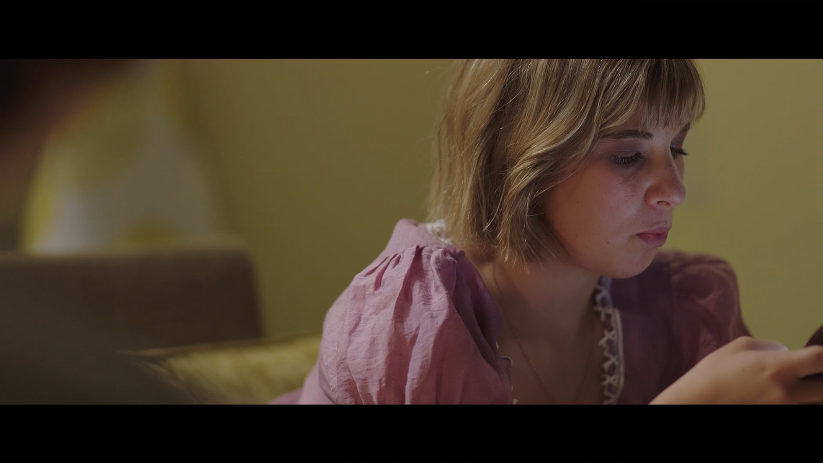 Between Worlds: A woman looking down at a table