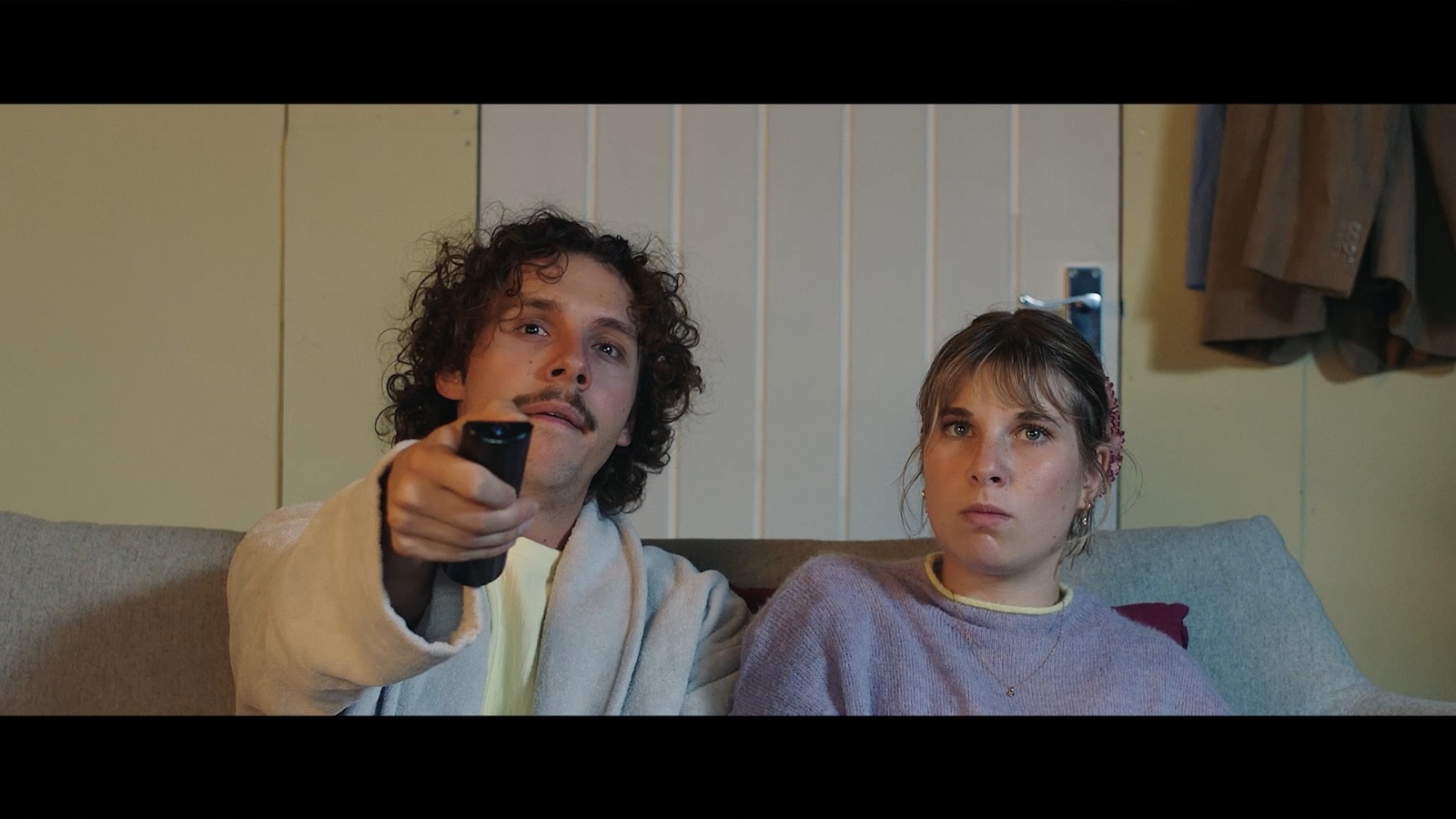 Between Worlds: Two people seated on a sofa