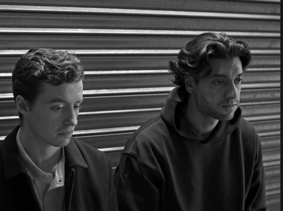 Find My Phone: Two men beside a metal shutter
