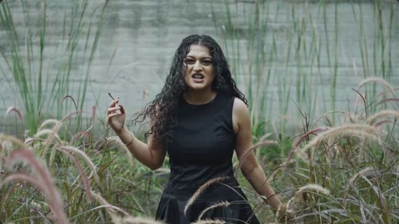 Choke: The singer standing among tall grasses